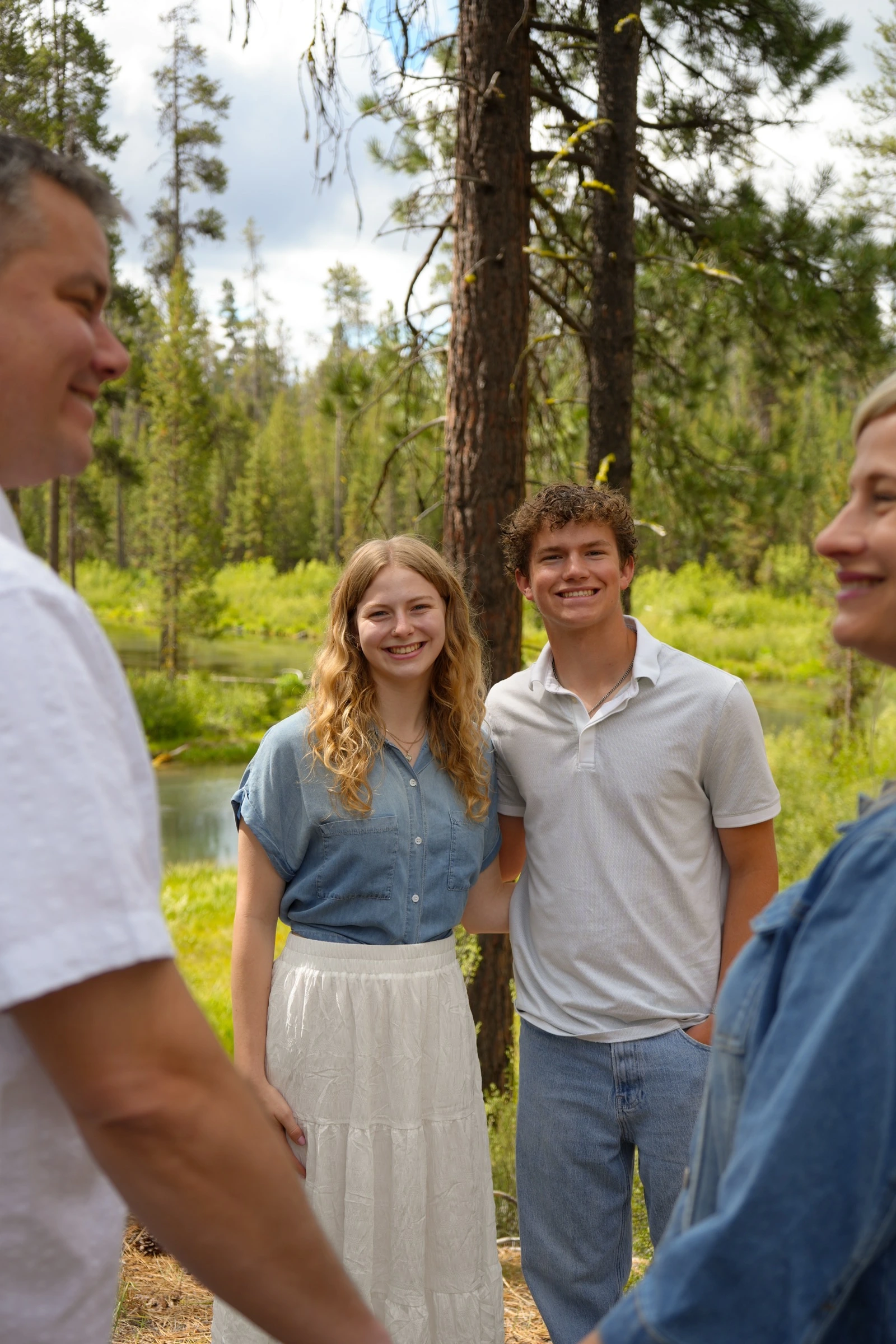 Young couple framed by family members in a forest portrait