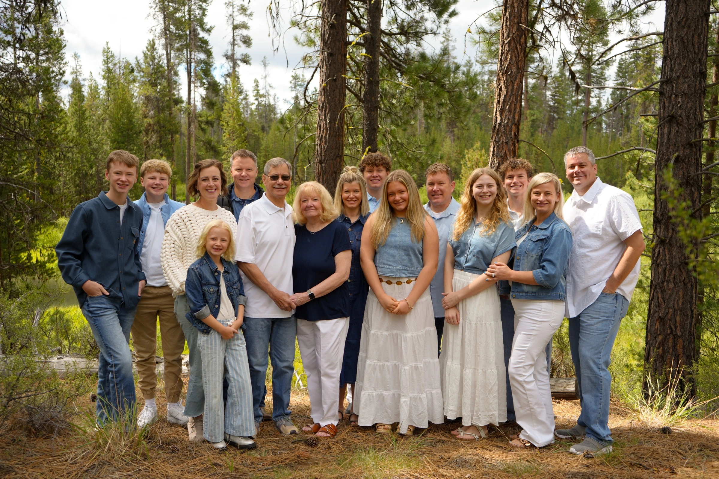 Large family group portrait in a wooded clearing