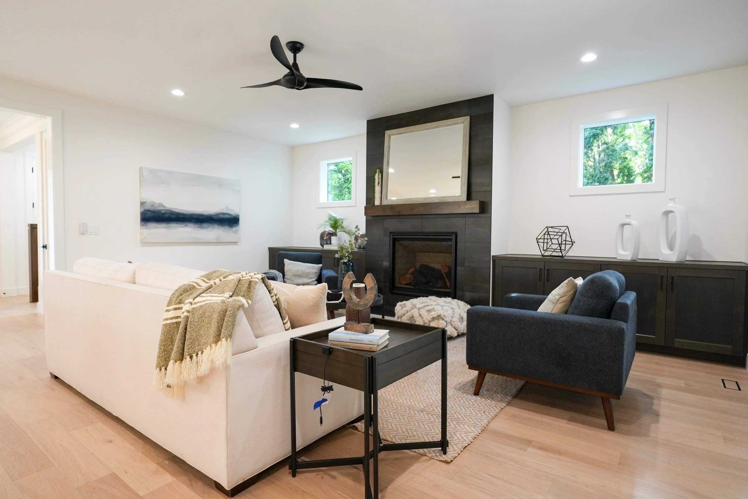 Bright staged living room with navy chairs and a modern fireplace