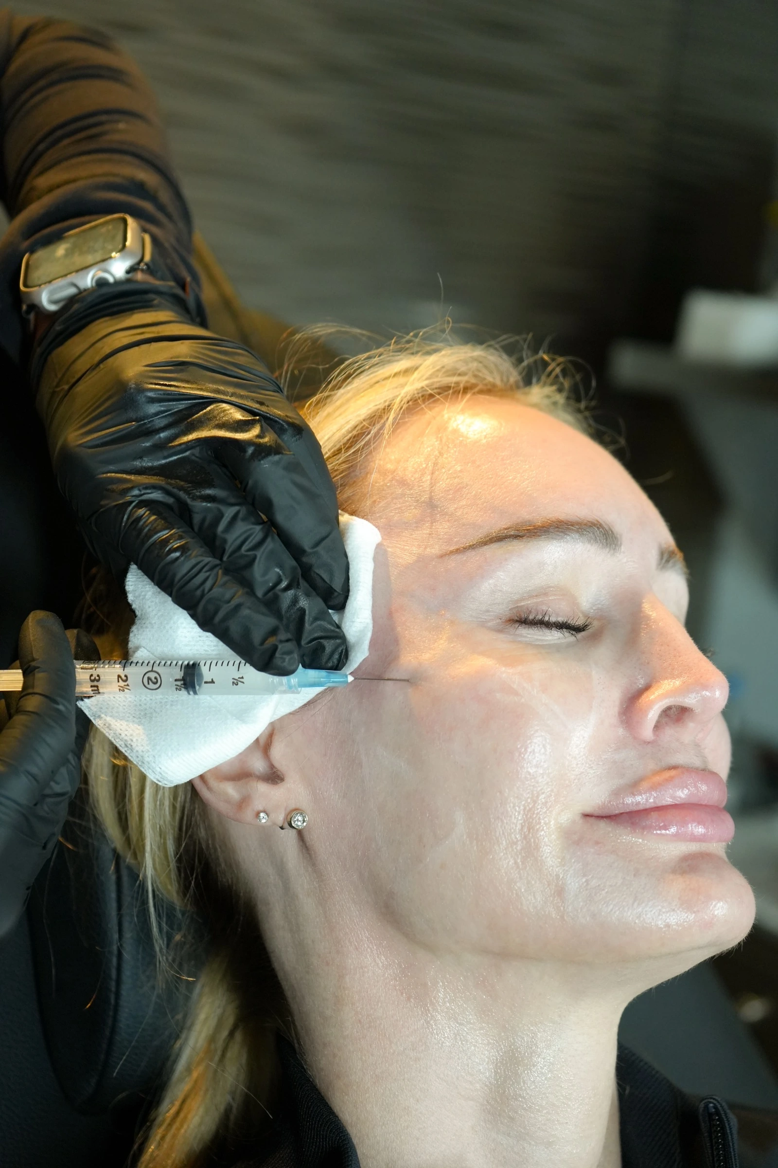 Practitioner performing a facial filler injection in a medspa