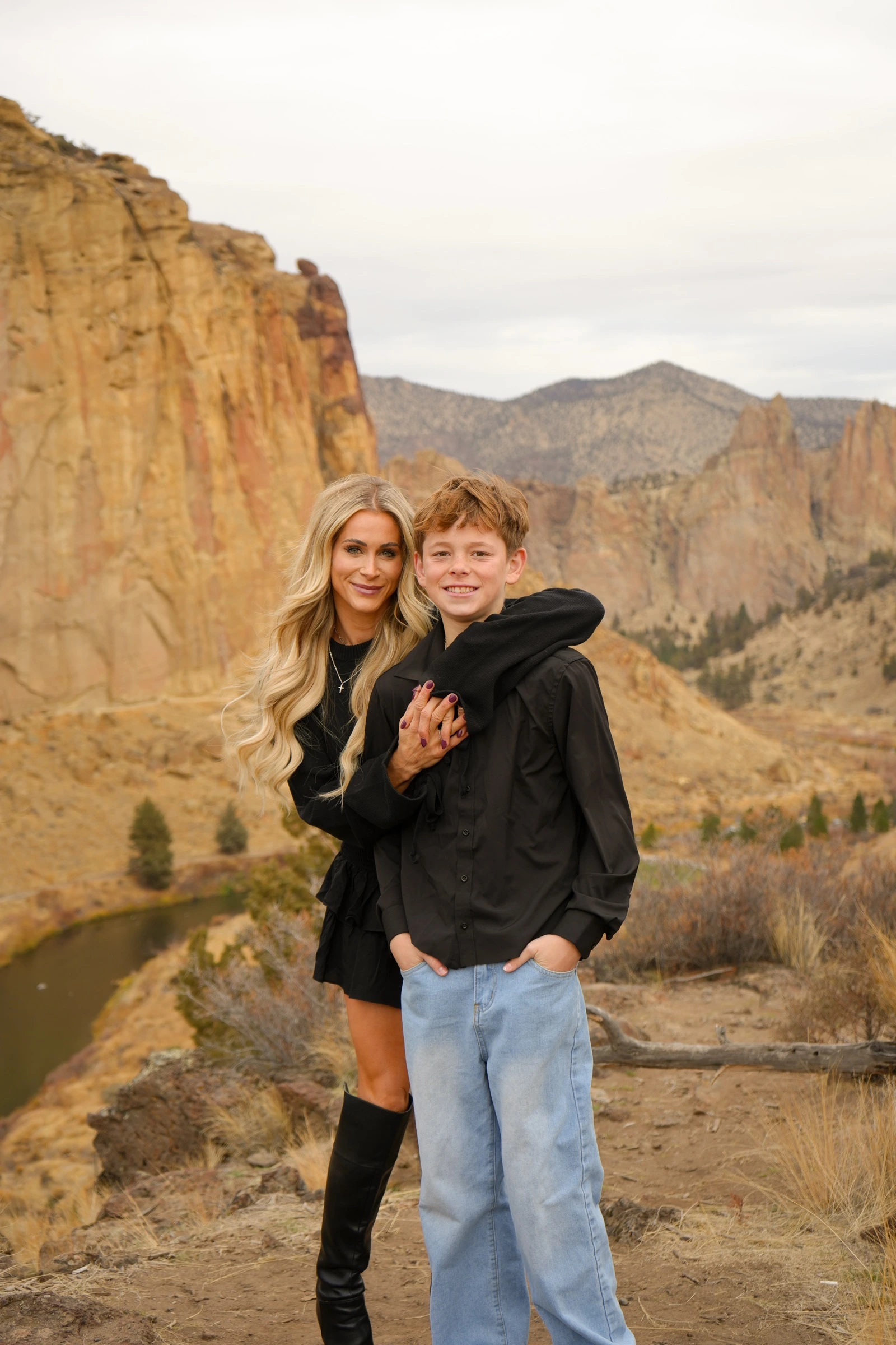 Mother and son standing together in a desert canyon landscape